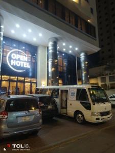 فندق اوبن هوتيل مكه المكرمه في مكة المكرمة: سيارة فان بيضاء متوقفة أمام الفندق