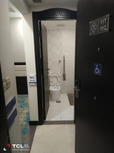 a bathroom with a toilet with the door open at فندق اوبن هوتيل مكه المكرمه in Mecca