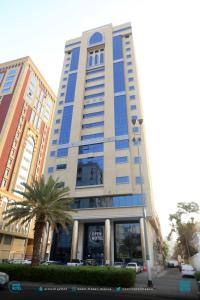 un edificio alto con una palmera delante de él en فندق اوبن هوتيل مكه المكرمه en La Meca