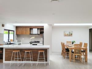 a kitchen and dining room with a table and chairs at Bay Villa with 5 Bedrooms and 5 Bathrooms in Whangaparaoa