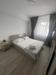 - une chambre avec un grand lit et une fenêtre dans l'établissement Luxury Apartment, à Piteşti