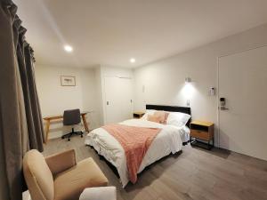 a bedroom with a bed and a desk and a chair at Bay Villa with 5 Bedrooms and 5 Bathrooms in Whangaparaoa