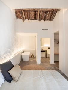a white bedroom with a bed and a bath tub at Casa cristo 37 navarrés in Navarrés