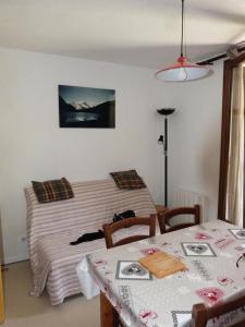 ein Schlafzimmer mit einem Bett und einem Tisch mit 2 Stühlen in der Unterkunft Residence Le Thymel - 2 Pièces pour 4 Personnes 44 in Valloire