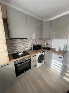 a kitchen with white cabinets and a stove top oven at Luxury Apartment in Piteşti