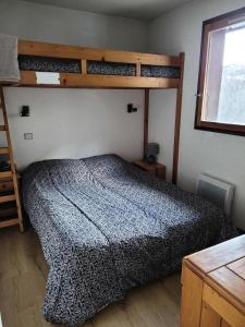 een slaapkamer met een bed en een stapelbed. bij Résidence Plan Soleil - 2 Pièces pour 4 Personnes 24 in Valloire