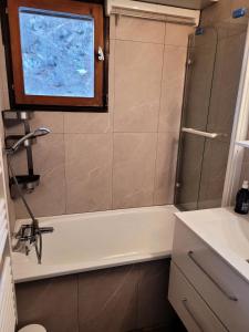 een badkamer met een bad en een wastafel bij Résidence Plan Soleil - 2 Pièces pour 4 Personnes 24 in Valloire