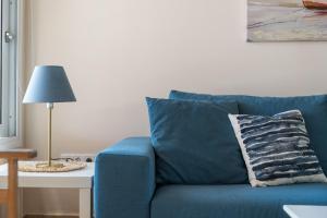 a blue couch in a living room with a lamp at Andreas House in Lixouri