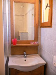 a bathroom with a sink and a mirror and a mirror at Chalet Les Aiguilles - Pièces 34 in Valloire