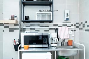 a kitchen counter with a microwave and a sink at Casa de Huespedes Colonial in Santo Domingo