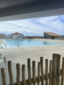 a view of a swimming pool through a fence at Résidence Bar-le Barcares - Pièces 664 in Le Barcarès