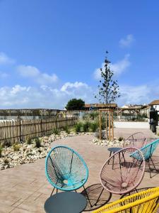 a group of chairs and tables on a patio at Résidence Bar-le Barcares - Pièces 664 in Le Barcarès