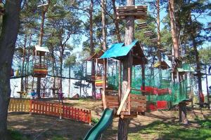 un parque infantil con un árbol y un tobogán en Apartamenty Royal Maris 1 - najlepsza lokalizacja w Ustce, blisko plaży i portu, bezpłatny parking, ścisłe centrum, en Ustka