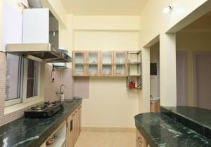 - une cuisine avec des comptoirs verts et une cuisinière dans l'établissement Camilla Living- A Luxury Escape by the Riverside!, à Guwahati