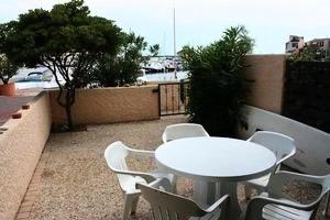 Biały stół i białe krzesła na balkonie w obiekcie Résidence Palmyra - 2 Pièces pour 4 Personnes 414 w mieście Le Barcarès