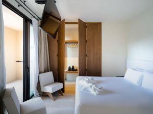 a hotel room with a white bed and a tv at Mercure Benidorm in Benidorm +37 photos