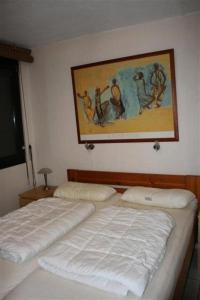 twee bedden in een slaapkamer met een schilderij aan de muur bij Résidence Bd Guadeloupe - 3 Pièces pour 6 Personnes 464 in Le Barcarès
