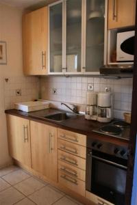 een keuken met houten kasten en een fornuis met oven bij Résidence Bd Guadeloupe - 3 Pièces pour 6 Personnes 464 in Le Barcarès