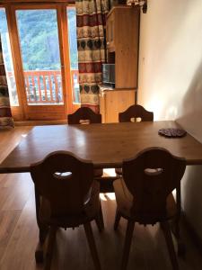 uma mesa de jantar com cadeiras e uma grande janela em Résidence Gentiane Hameau De La Vallee D'or - 2 Pièces pour 4 Personnes 84 em Valloire