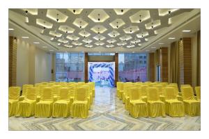 una sala de conferencias con sillas amarillas y techo en Hotel Grand Surya en Kodarma