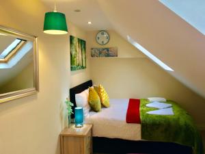 sypialnia z łóżkiem i zegarem na ścianie w obiekcie 1 Bed Apartment,Recep,Kitchen,Bath w mieście Ilford