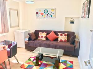 a living room with a brown couch and a table at 1 Bed Apartment,Recep,Kitchen,Bath in Ilford