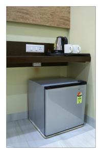 a small refrigerator under a counter in a kitchen at Hotel Grand Surya in Kodarma