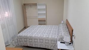 Apartamento Romero في كارافاكا دي لا كروز: غرفة نوم بسرير وطاولة مع مصباح