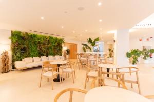 un restaurante con mesas y sillas y una pared verde en HL Rondo Hotel, en Playa del Inglés