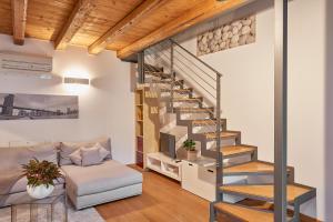 uma sala de estar com uma escada e um sofá em Casa Cozy - La Guarida em Pradamano