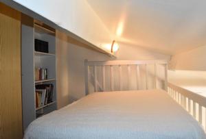 ein kleines Schlafzimmer mit einem Bett und einem Bücherregal in der Unterkunft Résidence LE HAMEAU DES PECHEURS - Maisons & Villas pour 4 Personnes 34 in Port Leucate