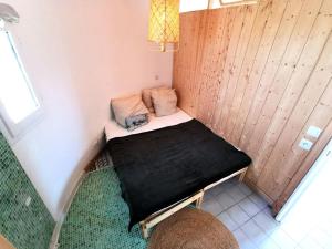 ein kleines Bett in einer Ecke eines Zimmers in der Unterkunft Résidence ILE DES PECHEURS - Maisons & Villas pour 6 Personnes 64 in Port Leucate