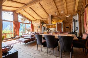 kuchnia i salon ze stołem i krzesłami w obiekcie Luxus Chalet Mühlermoos w mieście Ramsau im Zillertal