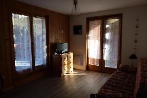 a living room with a tv and two windows at Chalet Du Regain - 3 Pièces pour 8 Personnes 94 in Valloire