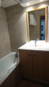 a bathroom with a sink and a tub and a mirror at Edelweiss Chalets De La Vallee D'or - 2 Pièces pour 4 Personnes 34 in Valloire