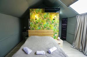 a bedroom with a bed and two purple slippers at პანორამა სხალტბა in Mtskheta