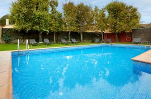 una gran piscina azul con sillas y árboles en Turismo Rural Mas Ametller, en Fontclara