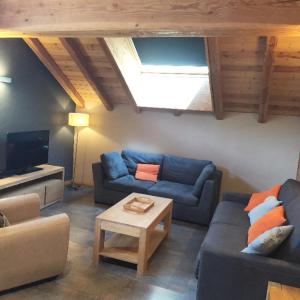 een woonkamer met een blauwe bank en een tafel bij Les Chalets D'adrien - 3 Pièces pour 6 Personnes 74 in Valloire