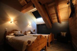 two beds in a room with wooden ceilings at Les Chalets D'adrien - 3 Pièces pour 6 Personnes 74 in Valloire