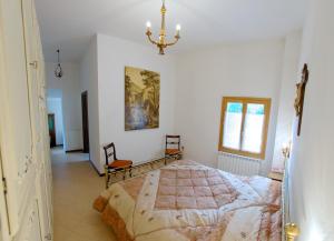 a bedroom with a bed and a chandelier at Podere Riosto Cantina&Agriturismo in Pianoro