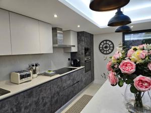 eine Küche mit einer Vase mit Blumen auf einer Theke in der Unterkunft Homely 6 bed Cottage 30 mins to Heathrow, London, Legoland, Windsor Castle in Little Missenden