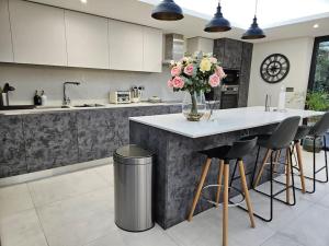 eine Küche mit einer Theke mit einer Blumenvase darauf in der Unterkunft Homely 6 bed Cottage 30 mins to Heathrow, London, Legoland, Windsor Castle in Little Missenden + 88 Fotos