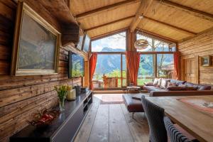 uma sala de estar com paredes de madeira e uma grande janela em Luxus Chalet Mühlermoos em Ramsau im Zillertal