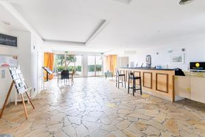 cocina y sala de estar con barra y sillas en Les Issambres Lauriers - maeva Home - Studio 4 personnes Confort 77 en Les Issambres