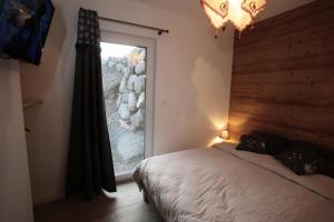 a bedroom with a bed and a large window at Les Chalets Du Grand Galibier - 3 Pièces pour 4 Personnes 44 in Valloire