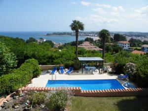 a swimming pool with chairs and a gazebo at Villa Erresiñolettean in Ciboure