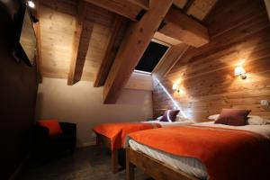 2 letti in una camera con pareti in legno di Les Chalets D'adrien - 3 Pièces pour 6 Personnes 84 a Valloire