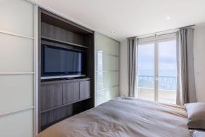 1 dormitorio con TV de pantalla plana y 1 cama en 2 bedrooms Duplex penthouse - Monaco border en Roquebrune-Cap-Martin