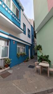 Room with Private Bathroom - Vivienda Vacacional Out of Blue في سانتا كروث دي لا بالما: مبنى باللون الأزرق والأبيض مع مقعد في ساحة الفناء