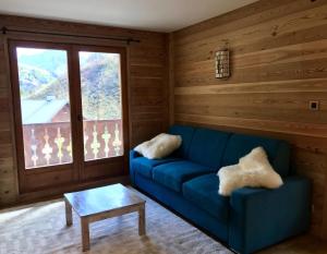 a living room with a blue couch and a table at Résidence Les Arolles - 2 Pièces pour 6 Personnes 24 in Valloire